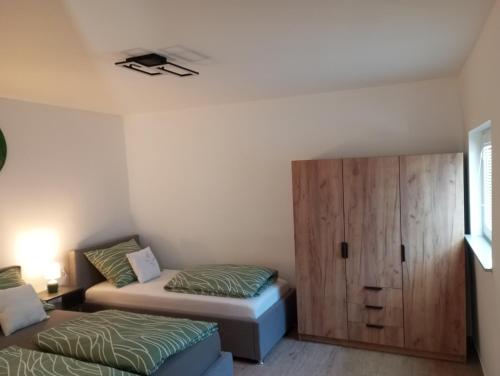 a bedroom with two beds and a cabinet at Vinea Apartma in Gornja Radgona