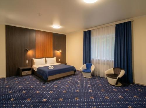 a hotel room with a bed and two chairs at Oasis Hostel in Kostanay