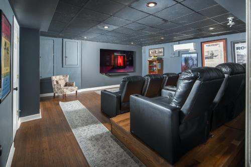 a waiting room with leather chairs and a flat screen tv at Appalachian Mountain Lodge in Boone