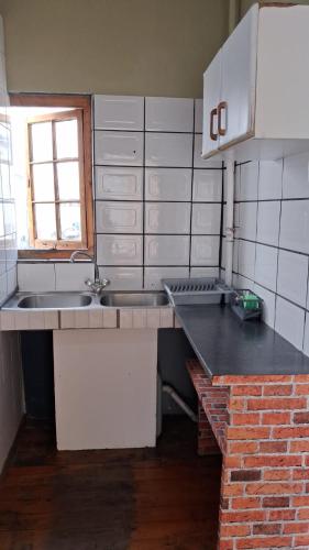 a kitchen with a sink and a counter top at Hostel Villa Nova in Mossel Bay