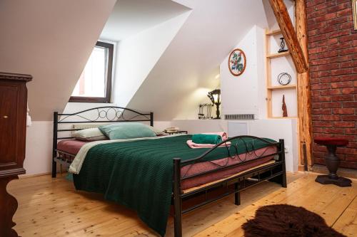 a bedroom with a bed with a green comforter at Libling Podkrovný in Banská Štiavnica