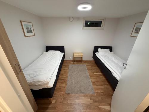 a room with two beds and a small table at Lägenhet 36B in Båstad