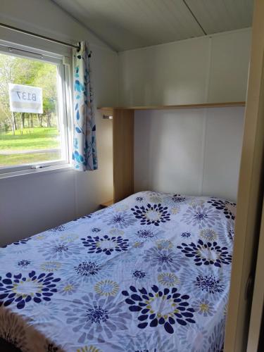 a bedroom with a bed with a blue and white comforter at TIthome in Cunlhat