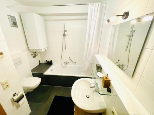 a bathroom with a sink and a toilet and a tub at Relax Holidays in Rheinheim