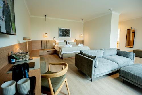 a living room with a bed and a couch at Farmer Hotel Basedow & Spa in Basedow