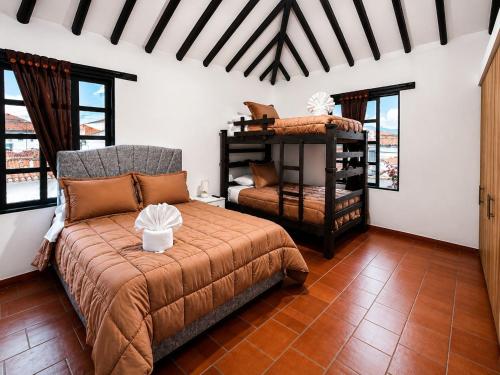 a bedroom with a bed and a chair and windows at hotel spa 360 villa de leyva in Villa de Leyva