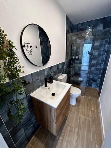 a bathroom with a sink and a mirror and a toilet at Apartamento Torrox Village in Torrox
