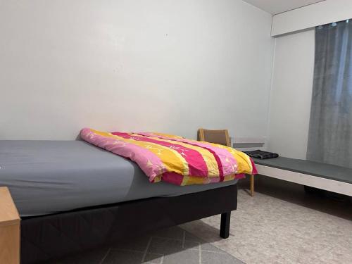 a bedroom with a bed with a colorful blanket on it at Private Room in Shared Apartment in Vaasa