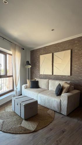 a living room with a large couch and a large window at Apartamento Rural en Valencia de Alcántara in San Pedro