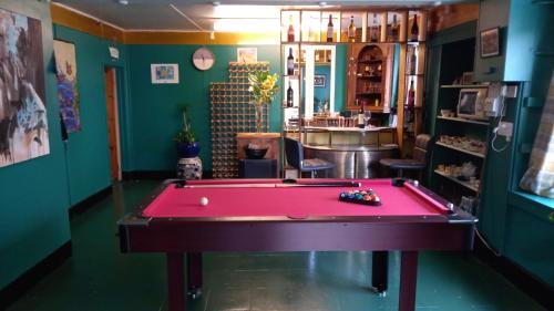 a red pool table in a room with green walls at The Post Office, 6 beds, Bar, Library, Pool Table, Stream, Large Garden in Piddletrenthide