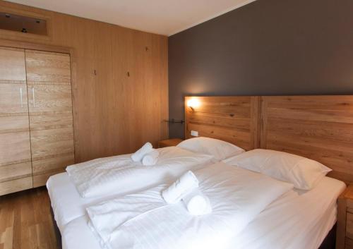 two beds in a bedroom with white sheets and pillows at Appart Laijola in Gaschurn