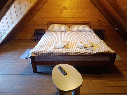 ein Bett in einem Holzzimmer mit Holzboden in der Unterkunft Sweet Dalia in Molvice