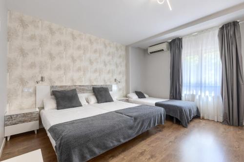 a bedroom with two beds and a window at Hotel Vivar in Griñón