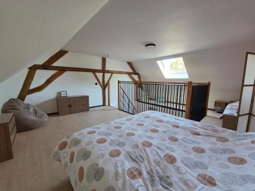 a bedroom with a large bed in a attic at L oasis de Détente - le Cocon - gîte 4 personnes avec 1h d accès à la piscine privée et terrasse aménagée par nuit réservée - climatisation - à 2km de Pairi Daiza in Brugelette