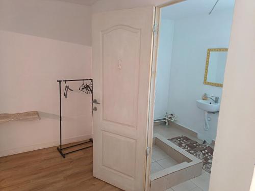 a bathroom with a white door and a sink at Mini vacanta in Tăşnad