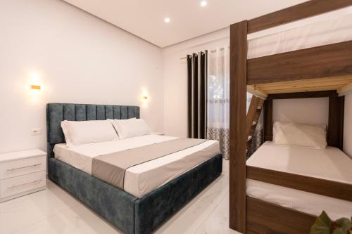 a bedroom with two beds and a bunk bed at Sunrise Hotel Vila in Vlorë