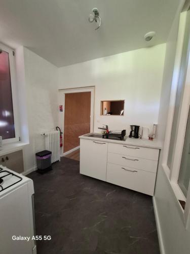 a kitchen with white cabinets and a counter top at Ty Méluzhine in Huelgoat