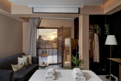 a living room with a couch and a view of a balcony at Clyde Athens by Stay Unique in Athens