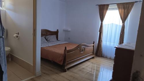 a bedroom with a bed and a window at Mini vacanta in Tăşnad