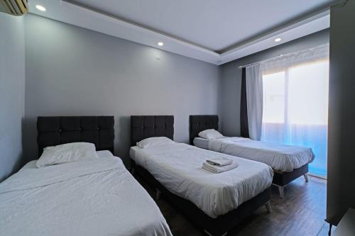 two twin beds in a room with a window at Villa ay yıldız in Belek