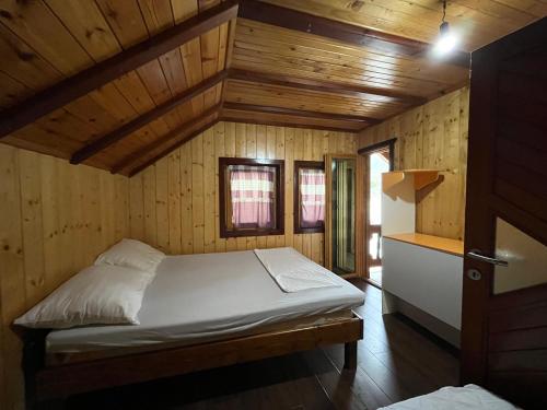 a bedroom with a bed in a wooden cabin at Vikendica Jablaničko jezero in Jablanica