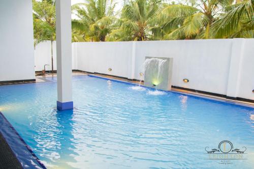 a pool with a water slide in a resort at Leighton Resort in Negombo