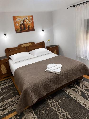 a bedroom with a large bed with two towels on it at Gyongyver Panzio in Sfântu-Gheorghe
