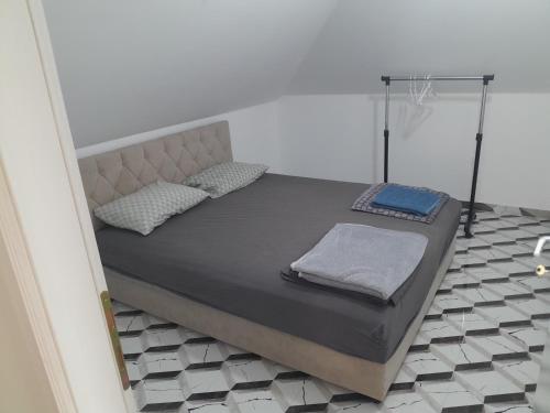 a bed with two pillows on it in a room at Apartman Maga 2 in Gnjilišta