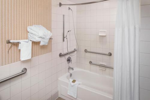 a bathroom with a tub and a shower with towels at Wyndham Columbus in Worthington