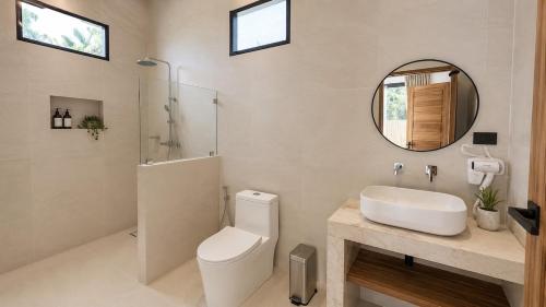 a bathroom with a toilet and a sink and a mirror at Maprao Tropical Home in Ko Phangan