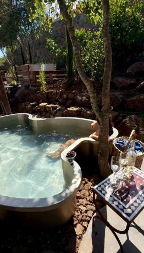 a hot tub with a table next to a tree at Healing Hands in Merom Golan