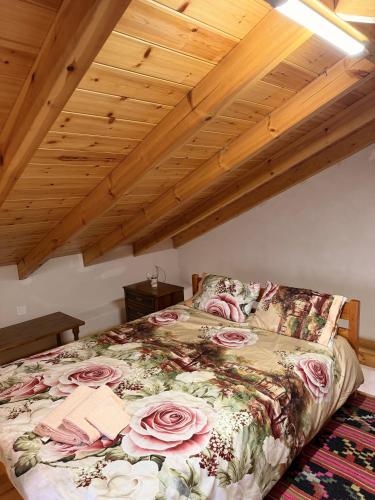 a bedroom with a bed with pink roses on it at The Stone Loft in Arfará
