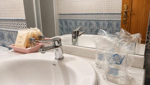 a bathroom with a sink and a mirror and a sink at Hostal Don Juan in Alarcón
