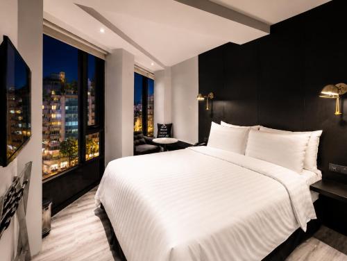 a bedroom with a large white bed and a window at Hotel Relax III in Taipei