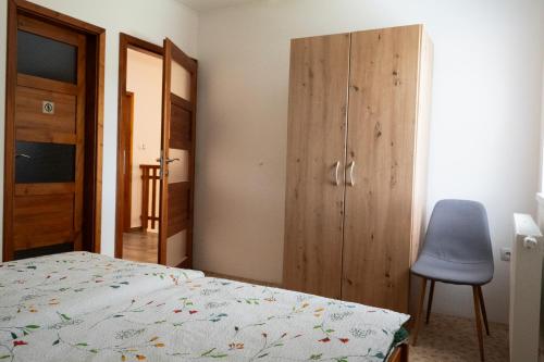 a bedroom with a bed and a chair and a cabinet at Ubytování Dědinka in Mladkov