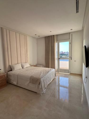 a bedroom with a bed and a large window at Dar Llama in Nador
