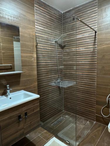 a bathroom with a glass shower and a sink at Dar Llama in Nador