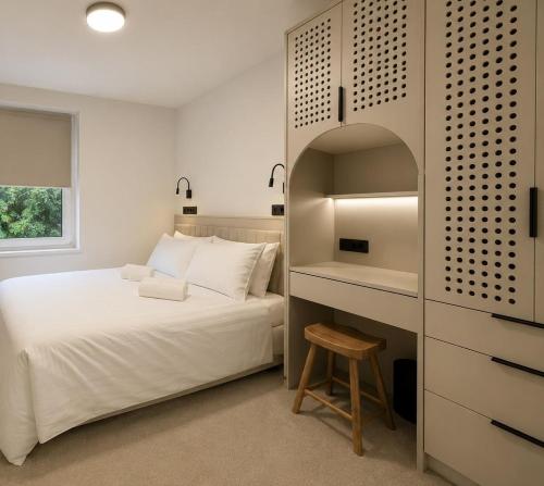 a bedroom with a white bed and a desk at Mavrin Home Zagreb, free parking, 3,8km from Old Town, Breakfast in Zagreb