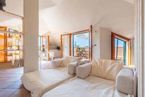 a living room with a white couch and a balcony at Maison Blanche in Bordighera