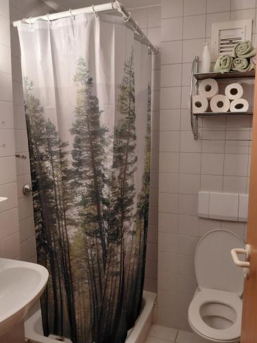 a bathroom with a shower curtain with trees at Apartment 35, 36 Christopherhof Grafenwiesen in Grafenwiesen