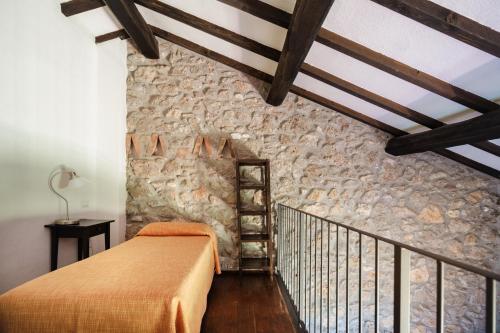 a bedroom with a bed and a stone wall at Agriturismo Ristorante Monte Argentario in Monte Argentario