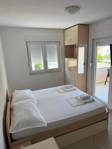 a bedroom with a bed with two towels on it at Apartmani Šantić in Baška Voda