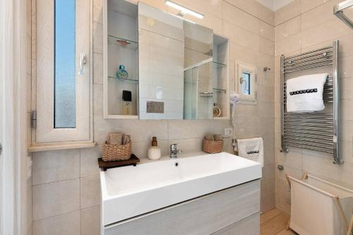 a white bathroom with a sink and a mirror at DIEGOPAS Sweet Home in SantʼAntonio Abate