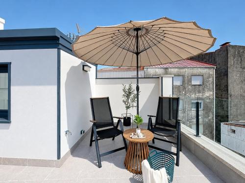 a patio with a table and chairs and an umbrella at Casa PedraMar in O Grove