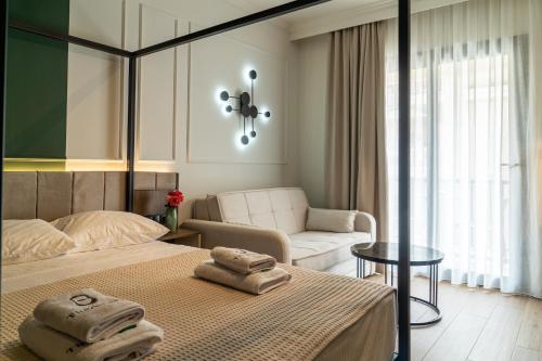 a bedroom with a bed with towels on it at Villa Theodora Boutique Stay in Fanari