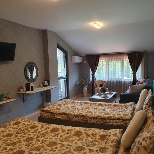 a bedroom with two beds and a living room at Lake View Deluxe Tryavna БЕЗПЛАТНИ БАСЕЙН И ПАРКИНГ in Tryavna