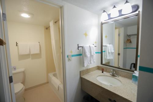 a bathroom with a sink and a toilet and a mirror at Nativo Lodge in Albuquerque
