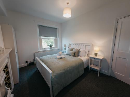 a bedroom with a bed with a stuffed animal on it at Peak Cottage in Matlock