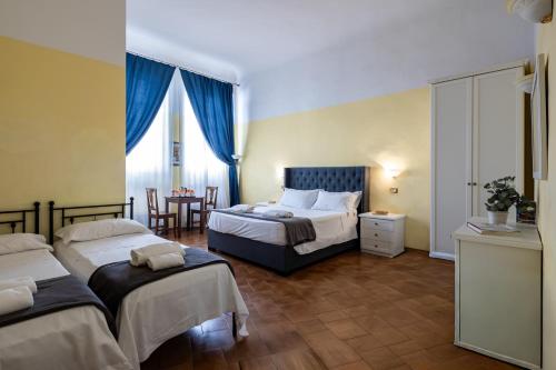 a hotel room with two beds and a table at Guesthouse Bel Duomo in Florence