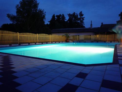 una piscina iluminada por la noche en Hotel Bellevue, en Doksy